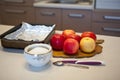 bright red apples in the kitchen, baking tray with foil for baking,