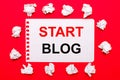 On a bright red background, white crumpled sheets of paper and a sheet of paper with the text START BLOG Royalty Free Stock Photo