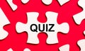 On a bright red background, white puzzles. In one of the pieces of the puzzle, the text QUIZ