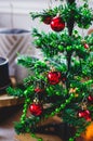 Bright red balls shine on a miniature decorative christams tree