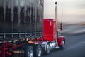 Bright red big rig semi truck with covered semi trailer going on the road for delivery Royalty Free Stock Photo