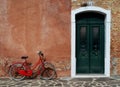 Bright red bike and green door Burano Italy Royalty Free Stock Photo