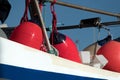 Bright red boat fenders hanging of a starboard of a boat docked in Westhaven