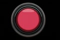 Bright red button resting on a dark surface in a minimalist design setting Royalty Free Stock Photo