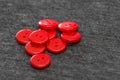 Bright red buttons. Gray fabric. Blurred background. The concept of the clothing industry and decor Royalty Free Stock Photo