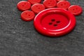 Bright red buttons. Gray fabric. Blurred background. The concept of the clothing industry and decor Royalty Free Stock Photo