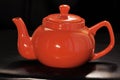 Bright red ceramic teapot or brewing teapot on a black background. Small kettle, afternoon tea-drink hot tea Royalty Free Stock Photo