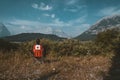 Bright red chairs with canada logo overlooking grass and mountains with lake in Lower Kananaskis Lake, Canada