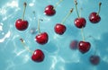 Bright red cherries float in clear blue water with light ripples and shadows. Refreshing summer berries backdrop. Fresh fruit Royalty Free Stock Photo