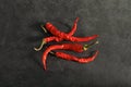 Bright red chili peppers on a dark background. Gastronomy, cookery. Secrets of delicious food. Condiments and spices