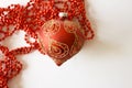 Red Christmas ball with golden decor and beads on a white background. a card for a Merry Christmas and a Happy New Year. Royalty Free Stock Photo