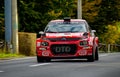 Bright red Citroen car driving along a racetrack during a hill climb race