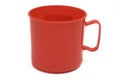 A bright red colored plastic mug cup with handle white backdrop Royalty Free Stock Photo
