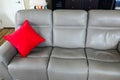 Bright red decorative pillow on the left end of a sofa Royalty Free Stock Photo