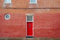 Red door on red brick building Royalty Free Stock Photo