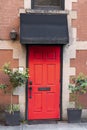 Bright red exterior front door with black awning Royalty Free Stock Photo