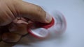 Bright red fidget finger spinner in hand on white background