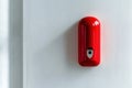 Bright red fire alarm pull station on white wall for safety and emergency awareness Royalty Free Stock Photo