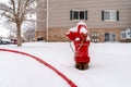 Bright red fire hydrant on the roadside of community covered with snow in winter Royalty Free Stock Photo