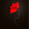 Bright red flower and a silhouette of a woman`s face on a black background