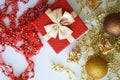 A red gift box with a golden bow. yellow and red beads for decoration or, brown and yellow balls on a white background. decoration Royalty Free Stock Photo