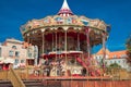 Bright red and golden carousel with horses and bright glowing lights turning around without passengers in darkness of Royalty Free Stock Photo