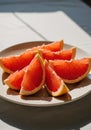 Bright Red Grapefruit Slices on a Plate in Sunlight Royalty Free Stock Photo