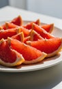 Bright Red Grapefruit Slices on White Plate Royalty Free Stock Photo
