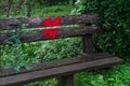 Bright red heart painted on the back of a wooden bench in the park Royalty Free Stock Photo