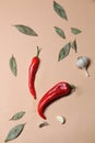 Bright red fresh hot chili peppers, bay leaves, garlic cloves on pink background; space for text Royalty Free Stock Photo