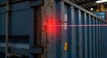 Precision laser marking on a weathered blue shipping container in an industrial warehouse setting Royalty Free Stock Photo