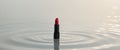 Bright Red Lipstick on Calm Water Surface with Soft Light Reflections Royalty Free Stock Photo