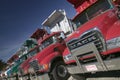 Bright red Mack dump trucks line the road in a row, in Maine near the New Hampshire border