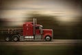 Bright red big rig semi truck and trailer in motion on a highway