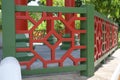 A bright red and olive green painted border concrete cement handhold railing of a pavilion at a park Royalty Free Stock Photo