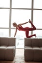 Strong resolute young lady leaning on two sofas