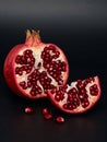Vibrant red pomegranate cut open revealing juicy arils against a dark background fruit 1 Royalty Free Stock Photo