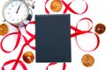 Bright red ribbon and a notebook with black pages and slices of dried lemon isolated on white background