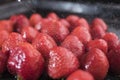 Bright red strawberry under the spray of drops of water on a black background, closeup Royalty Free Stock Photo