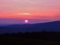 Bright red sunset and blue rolling hills Royalty Free Stock Photo