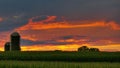 Bright Red Sunset over Corn Field with Silos Royalty Free Stock Photo