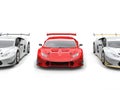 Bright red supercar with white sportscars on each side Royalty Free Stock Photo