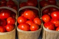 Bright red tomatoes in farmers wooden baskets at market