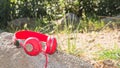 Bright red wired headphones on the rock