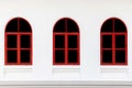 Bright red wooden windows and white cement wall Royalty Free Stock Photo