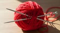 Bright red yarn ball with knitting needles, symbolizing creativity and handmade crafts Royalty Free Stock Photo