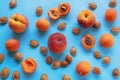 Bright ripe apricots and peaches and fruit stones on blue