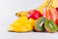 Bright ripe exotic fruits of red, yellow, green, orange color with juicy sliced slices macro on white wood background. Royalty Free Stock Photo