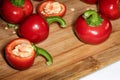 Bright ripe round red chili peppers cuts and seeds on wooden cutting board