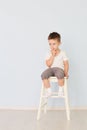 Bright room. Boy in white shirt sitting in a high chair